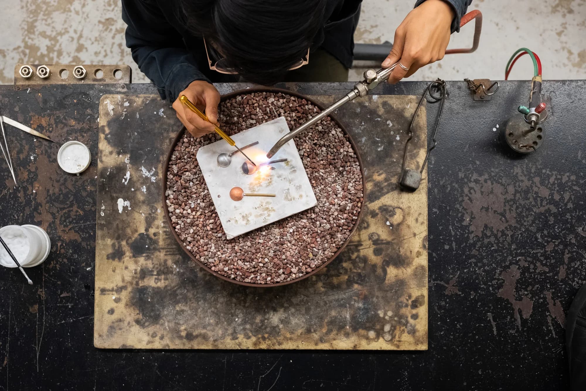 Artist soldering metalwork in the studio