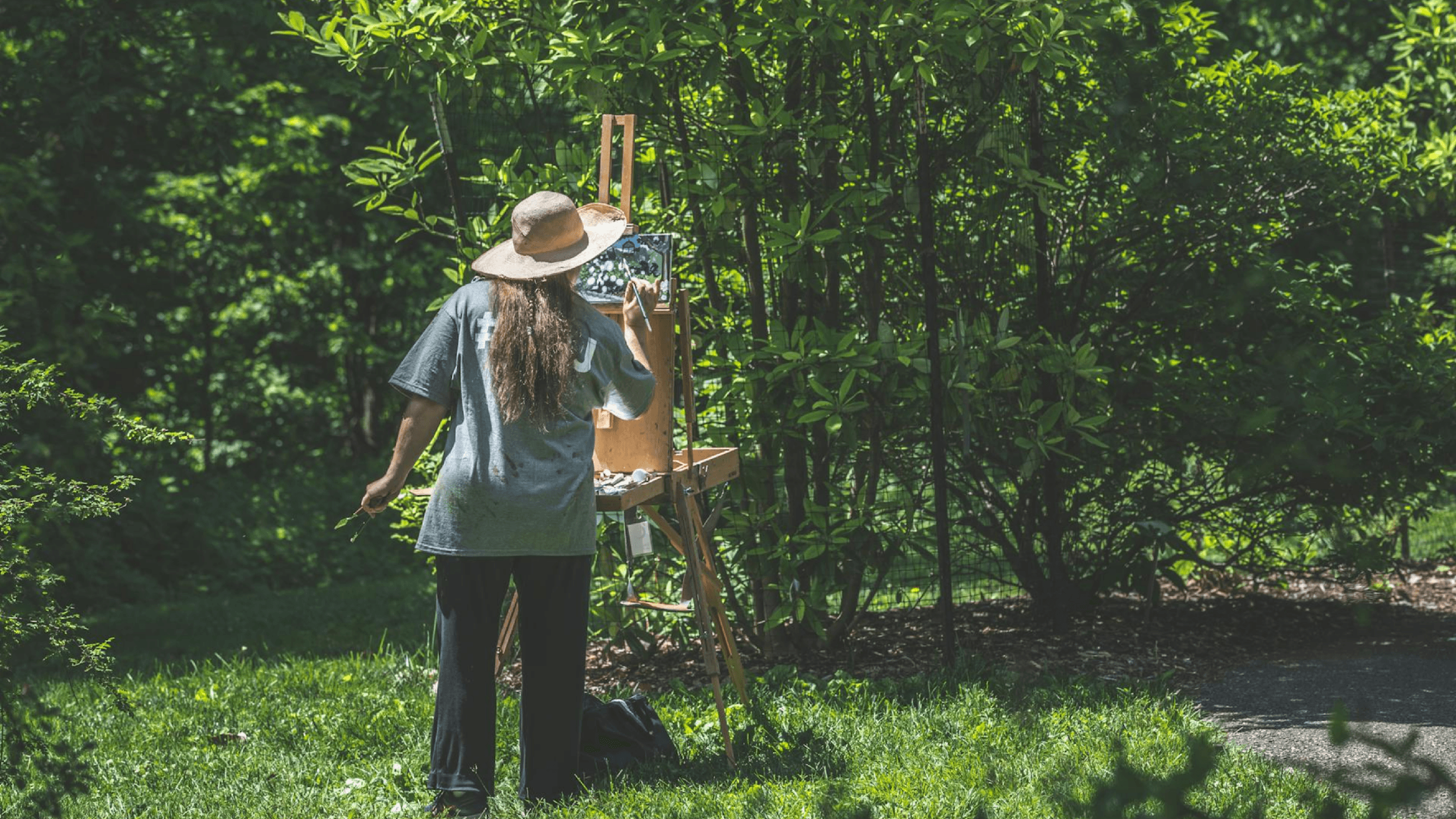 Artist painting outdoors in a garden